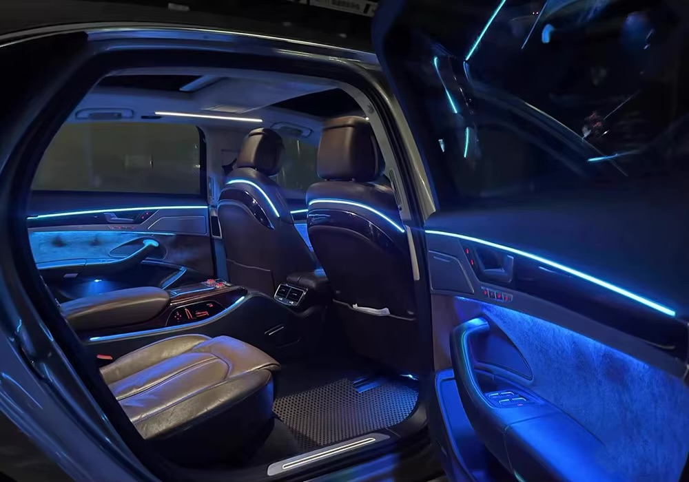 Custom blue ambient lighting installed along a car interior trim