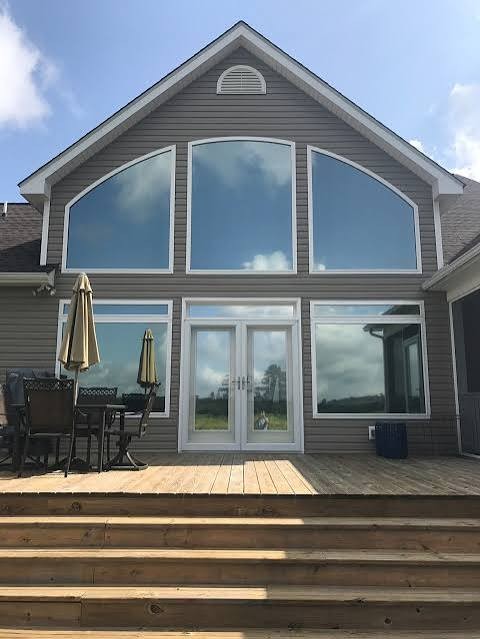Home with large tinted windows overlooking a deck